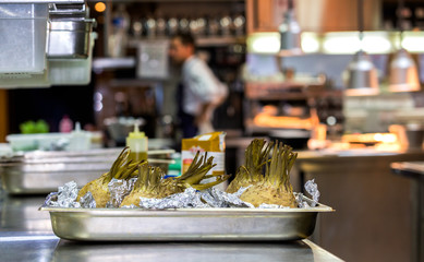 Vegetables in a tray with a chef in the background