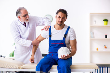 Young male contractor visiting old doctor