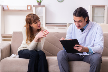 Young female patient discussing with male psychologist personal