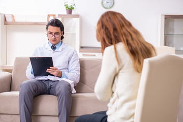 Young female patient discussing with male psychologist personal