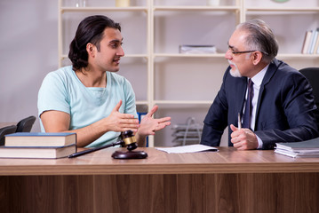 Young man visiting experienced male lawyer