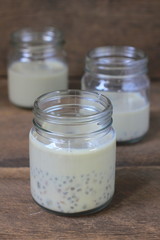 black sesame soy milk in glass on wood