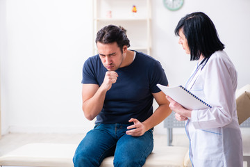 Fototapeta premium Young male patient visiting aged female doctor