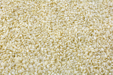 Food background of pile of raw white sesame seeds ingredient