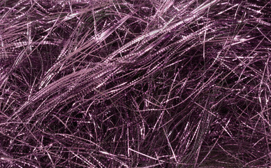Background of shiny purple thin tinsel strips for festive celebration