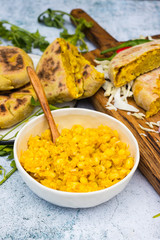 Yellow Mexican corn bread pies, tarts stuffed with sweet corn, maize kernels inside on wooden board.