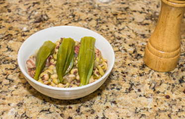 Bowl of Purple Hulled Peas Topped with Okra:  Bowl of freshly cooked purple hulled peas topped with boiled okra.