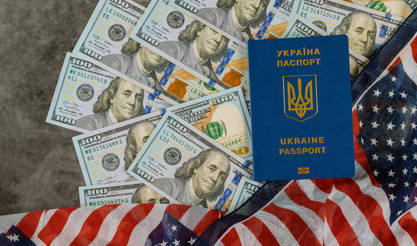 Ukrainian biometric passport in the US flag with bills of one hundred dollars