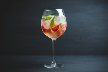 Martini royale cocktail in wine glass with basil leaves and strawberry. Selective focus. Shallow...