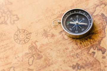 Old compass on vintage map. Retro stale. © Tawanboonnak
