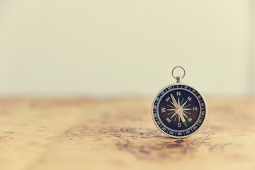 Old compass on vintage map. Retro stale. © Tawanboonnak