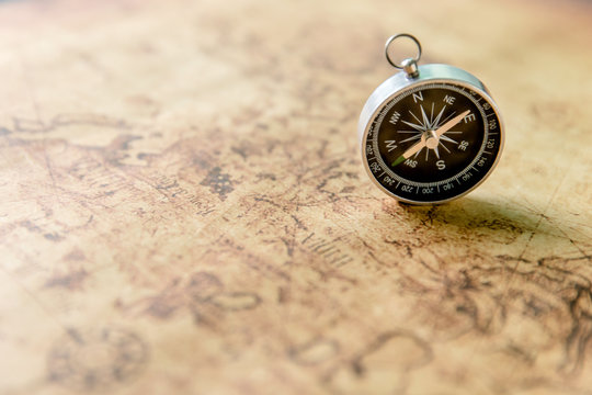 Old compass on vintage map. Retro stale.