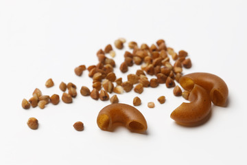 Pasta made from buckwheat flour and buckwheat groats on a white background