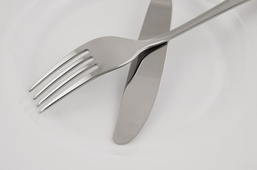 White plate with fork and knife close up