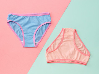 Blue and pink panties on a pink and blue background. The concept of meeting lovers. Underwear. The view from the top. - obrazy, fototapety, plakaty