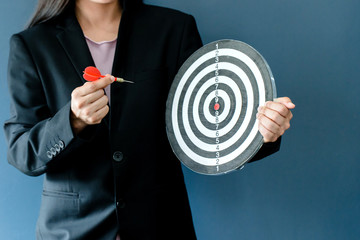 business women hand holding a target with three darts hitting the center over blue background. Concept of personal coaching success