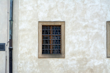 Fototapeta na wymiar Grilled window in the plastered wall