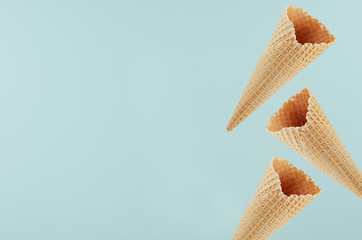 Empty ice cream cones as decorative border on pastel green background, mock up for advertising, design, menu.