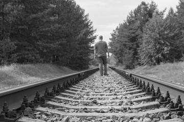 Lonely man walking on a railway track. Black and white tone