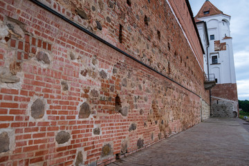 Photo of an ancient brick castle in nature in the summer.