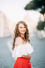 Portrait of a girl in a red dress and hat. Stylish bride on the streets of Rome.