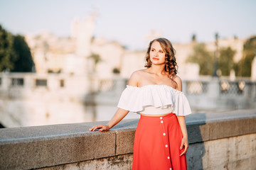 Portrait of a girl in a red dress and hat. Stylish bride on the streets of Rome.