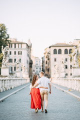 Stylish loving couple walking and laughing. Wedding shooting on the streets of Rome, Italy.