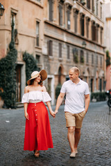 Naklejka premium Stylish loving couple walking and laughing. Wedding shooting on the streets of Rome, Italy.