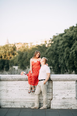 Stylish loving couple walking and laughing. Wedding shooting on the streets of Rome, Italy.