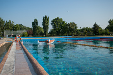 Swimmer standing next to a pool on a sunny morning