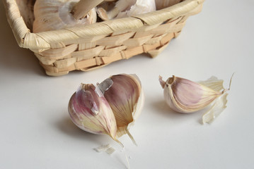 Heads and cloves of garlic in a wicker basket on a table