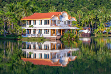 Tropical house in the form of a ship next to the sea in the jungle with green palm trees. Luxury beach resort on an island in Thailand. Nature and travel concept