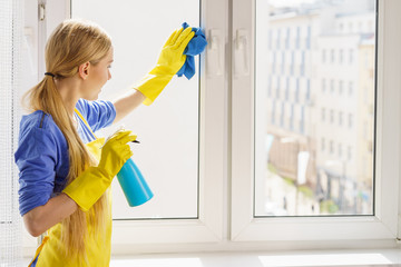 Woman cleaning window at home