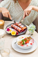 Woman eating pink pancake.