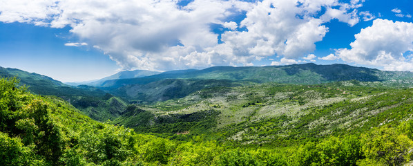 Fototapeta na wymiar Montenegro, XXL panorama view of green valley bjelopavlici plain lowlands from mountains near ostrog monastery with blue sky and thunderstorm clouds