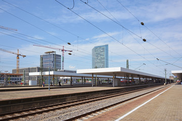 Fototapeta na wymiar Mannheim, Germany - July 2019: Tracks and platforms of Mannheim main train station on summer day with blue sky