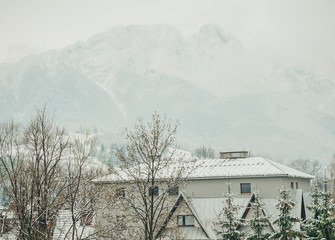 Foggy tatra mountains in winter with building on front.