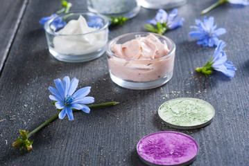 Obraz na płótnie Canvas moisturizer, bath salt and face powder samples on dark wooden background