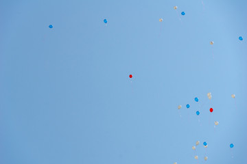 white, blue and red balloons in the sky