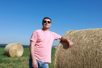 Naklejka na ściany i meble Person posing with bales of straw