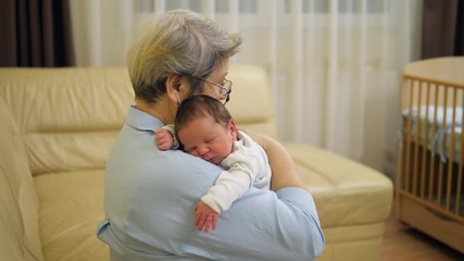 Sweet newborn bay sleeping on grandmother shoulder, home family comfort - Powered by Adobe