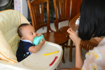 Asian baby boy 6 months old eating by himself with Baby Led Weaning (BLW) method, Self-Feeding