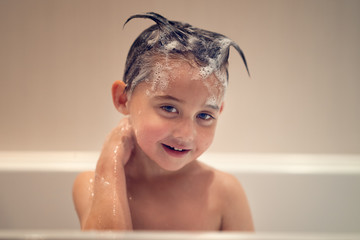 smiling boy washing in the bath