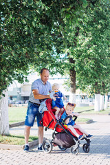 father take care children, stroller, summer, caucasian family