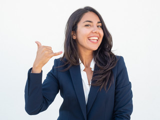 Cheerful manager making telephone gesture. Happy joyful young woman in office suit showing call me...