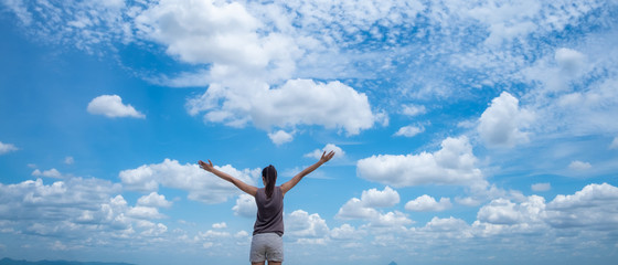 lifestyle concept - beautiful happy woman enjoying summer outdoors over blue sky.