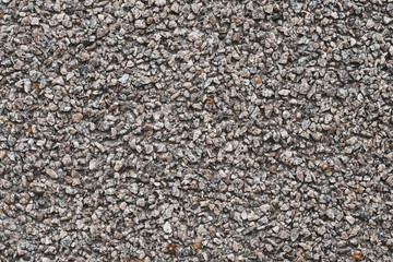Background of small brown and gray pebbles. Rough stone wall, abstract pattern. Surface, rock texture.