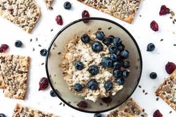 White background with grain cookies fresh blueberries, dried cranberries. Oatmeal with blueberries. Useful snack, proper nutrition. Healthy breakfast. Food for vegans.