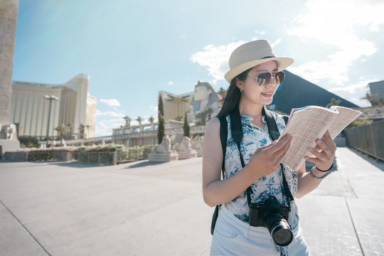 Sphinx and pyramid of Cheops in backgorund under blue sky. young female traveler visit resort and casino in Las Vegas Strip in Nevada United States. woman tourist holding guide book read information