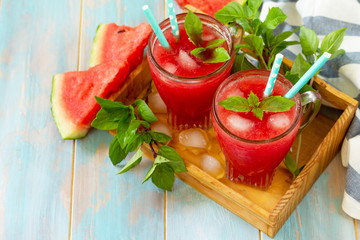 Cold Watermelon Smoothie. Summer Watermelon drink in glasses and slices of watermelon on rustic wooden table. Free space for your text.